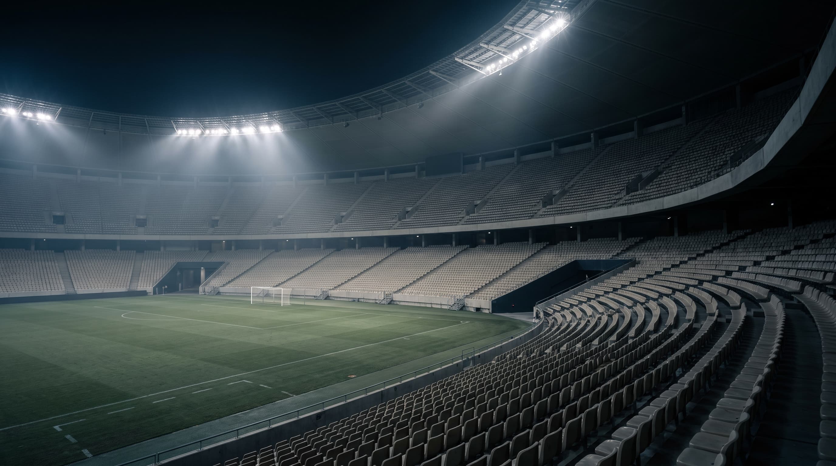 An empty stadium bowl at night under floodlights